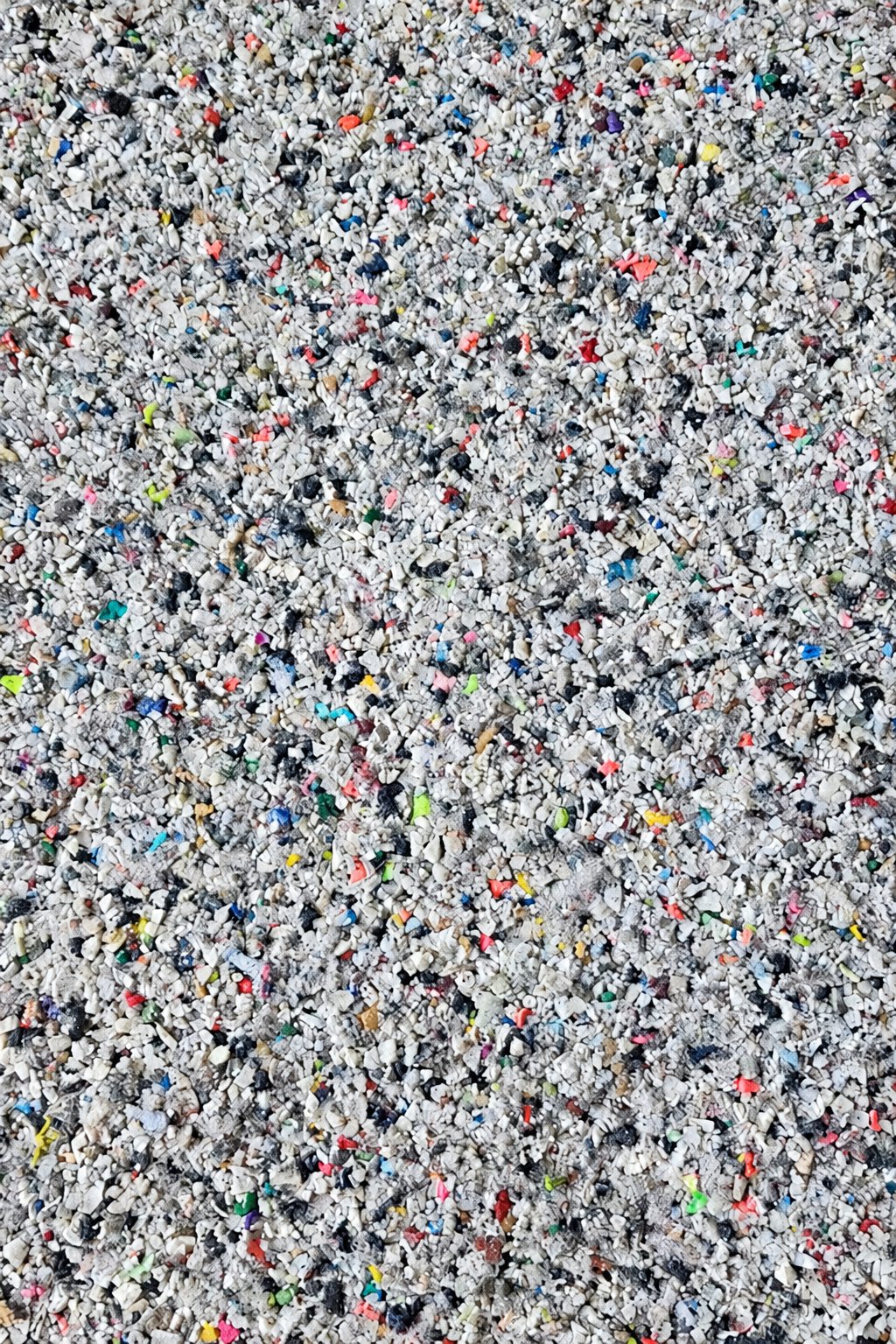 Recycled shoe EVA granules: light grey and white flakes with small coloured flecks.