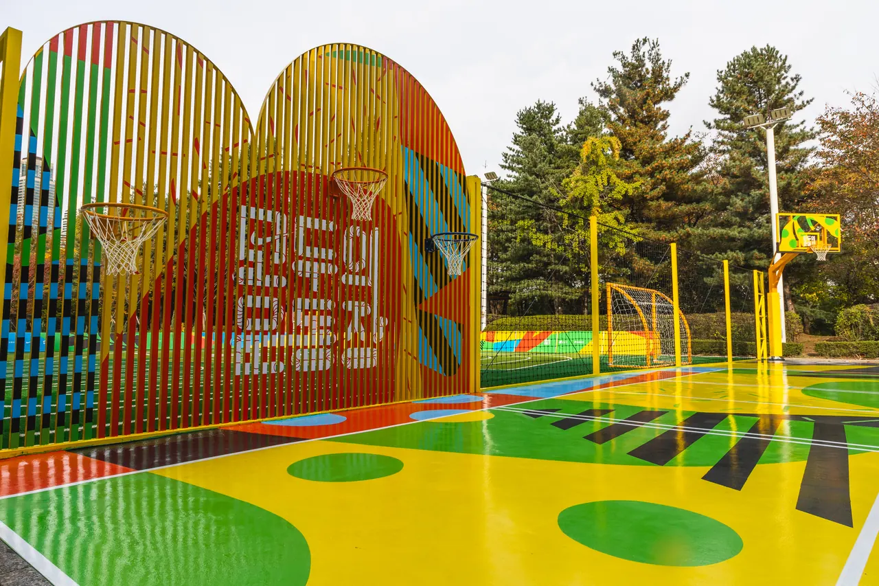 The glossy coloured surface at Modoo Gangnam at ground level, with line markings and the Modoo wall.